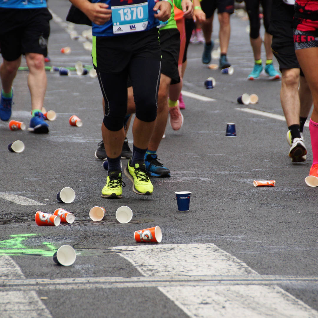 Discarded cups and litter covering the road during a marathon, ready for post-event cleaning